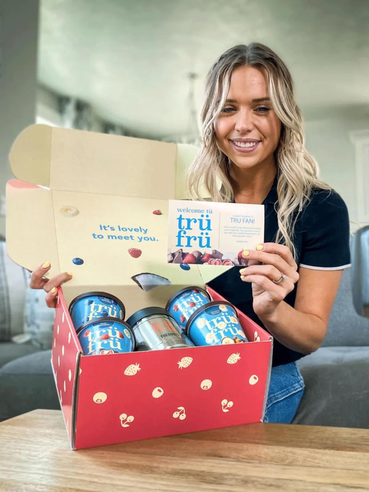 Employee holding an open branded gift box prepared as a welcome kit