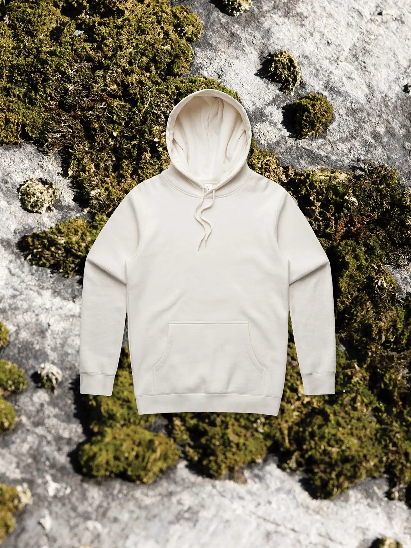 Neutral hoodie laying on sustainable background. 